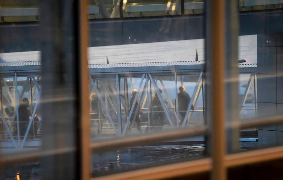 Bildet er tatt gjennom en glassrute, og viser folk som går gjennom en glasstunnel fra et fly og inn på flyplassen. Tre av de er svenske kvinner som er hentet fra Syria. Arkivfoto: NTB / TT / Fredrik Sandberg