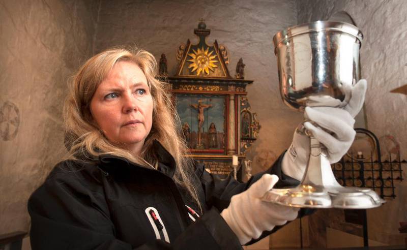 Kunsthistoriker Cathrine Lillo-Stenberg undersøker alterkalken i Tanum kirke i Bærum. W