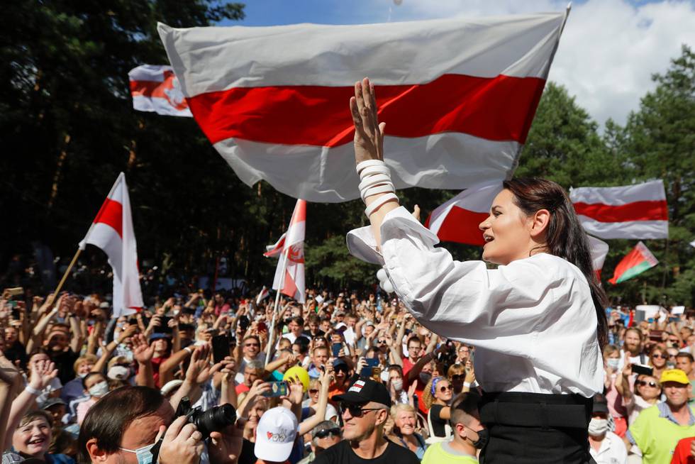 FILE In this file photo taken on Sunday, Aug. 2, 2020, Sviatlana Tsikhanouskaya, candidate for the presidential elections greets people waving old Belarus flags during a meeting to show her support , in Brest, 326 km (203,7 miles) southwest of Minsk, Belarus.  Belarus authoritarian President Alexander  Lukashenko faces a perfect storm as he seeks a sixth term in the election held Sunday, Aug. 9, 2020 after 26 years in office. Mounting public discontent over the worsening economy and his governments bungled handling of the coronavirus pandemic has fueled the largest opposition rallies since the Soviet collapse.  (AP Photo/Sergei Grits)