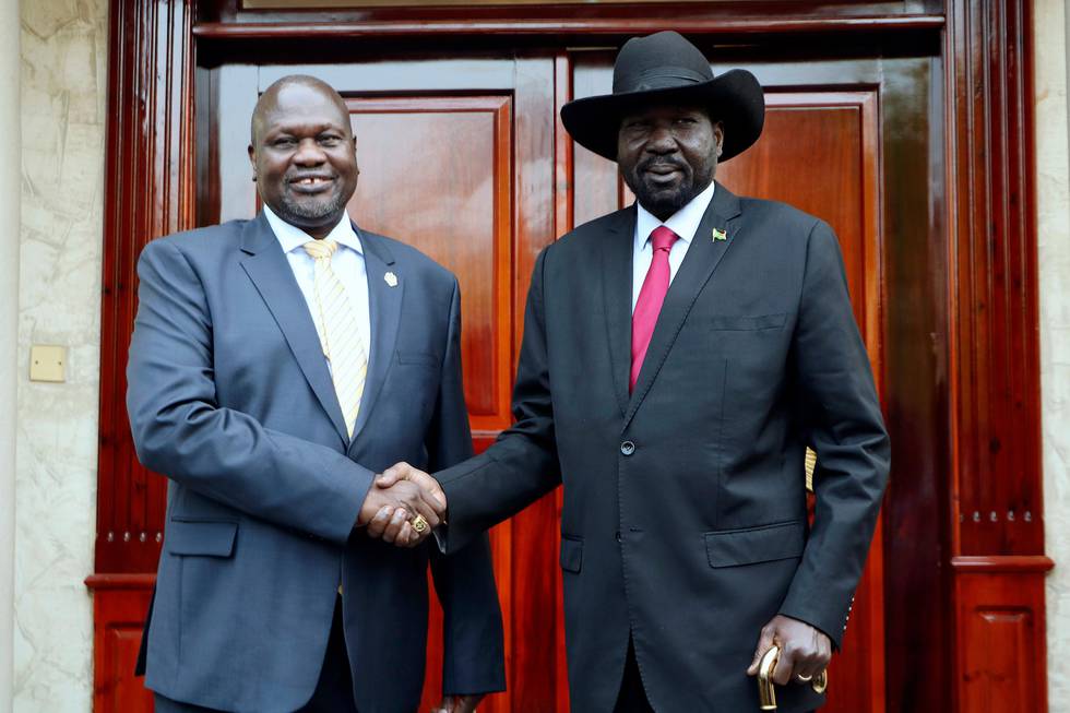 Dr. Riek Machar, left, greets South Sudan President Salva Kiir, right, on his arrival in Juba, South Sudan, Monday, Sept.9. 2019. South Sudan opposition leader Riek Machar returned on Monday to meet with President Salva Kiir and held talks in preparation for the formation of a coalition government in November.  (AP Photo/Sam Mednick)
