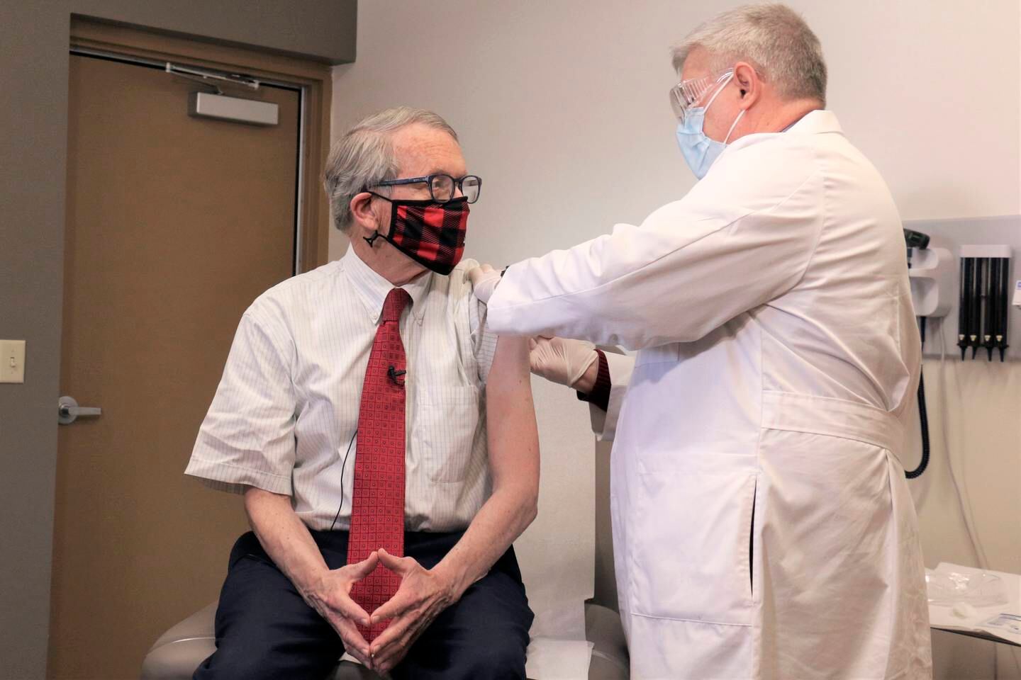FILE - In this Tuesday, Feb. 2, 2021 photo provided by the Ohio Governor's Office, Gov. Mike DeWine, left, gets his first dose of the COVID-19 vaccine from Dr. Kevin Sharrett, in Jamestown, Ohio. On Friday, April 9, 2021, The Associated Press reported on stories circulating online incorrectly asserting masks are no longer mandatory in Ohio, and DeWine isnt saying a word about it. But masks remain mandatory in Ohio in indoor spaces as well as outdoors when social distancing is not possible. Ohio rescinded its previous coronavirus health orders on April 5, but the state issued a new order the same day simplifying the guidelines. (Ohio Governor's Office via AP)