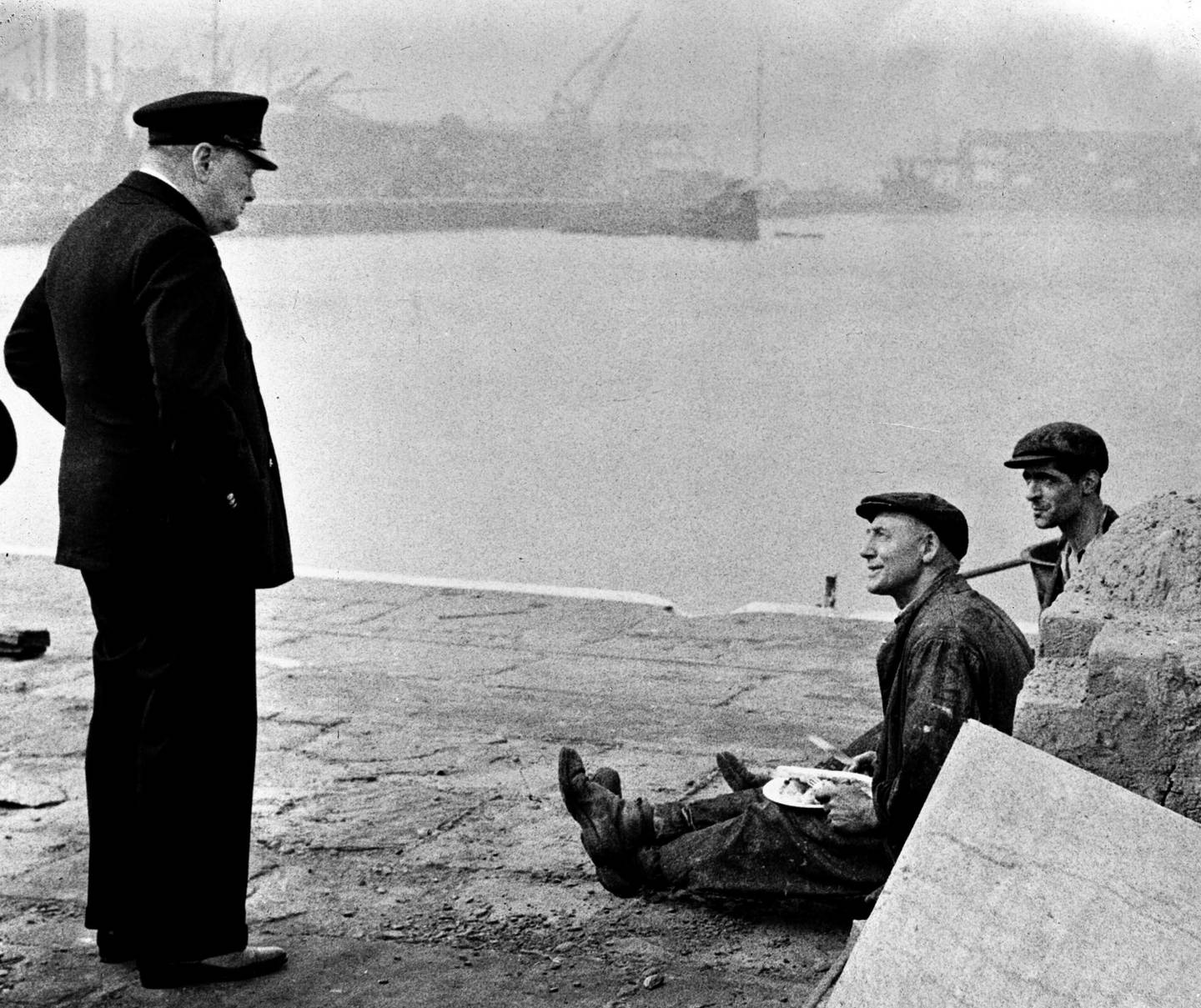 Britain's Prime Minister Winston Churchill, left, speaks to two workmen eating their lunch, in England, in September 1941, while touring a docks area. Upon seeing their well-filled plates, Churchill asked 