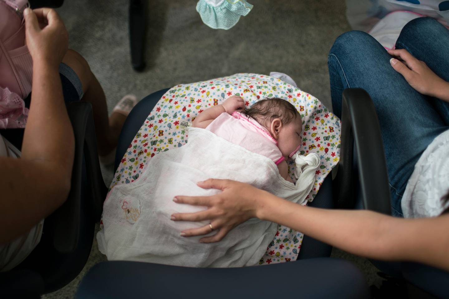 FILE - In this Dec. 22, 2015 file photo, Angelica Pereira, right, holds her daughter Luiza, disabled by the Zika syndrome, as she waits for their appointment with a neurologist at the Mestre Vitalino Hospital in Caruaru, Pernambuco state, Brazil. Treating children with neurological problems is not cheap. Researchers exploring the health burden for governments fighting Zika conclude that each child with microcephaly in Brazil would cost about $95,000 in lifetime medical expenses. (AP Photo/Felipe Dana, File)