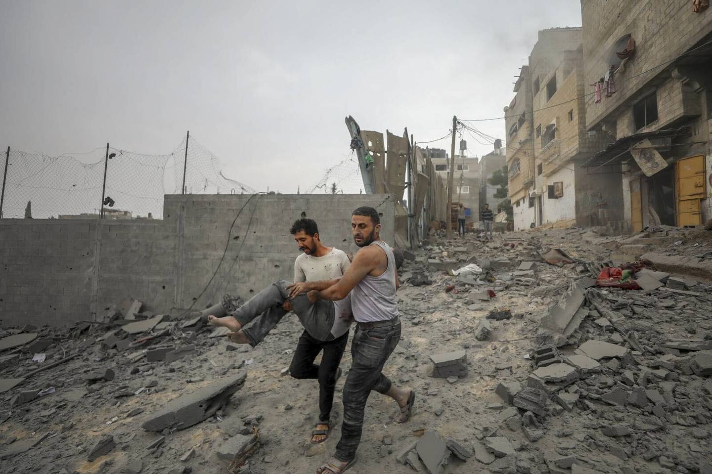 To palestinske menn evakuerer en såret person fra flyktningleiren Jabalia på Gazastripen etter et israelsk luftangrep. Foto: Mohammad Al Masri / AP / NTB