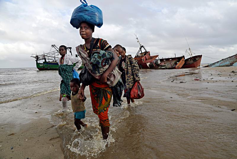 A displaced family arrives after being rescued by a boat from a flooded area of Buzi district, 200 kilometers (120 miles) outside Beira, Mozambique, on Saturday, March 23, 2019.  A second week has begun of efforts to find and help tens of thousands of people after Cyclone Idai devastated a large swath of Mozambique. (AP Photo/Themba Hadebe)