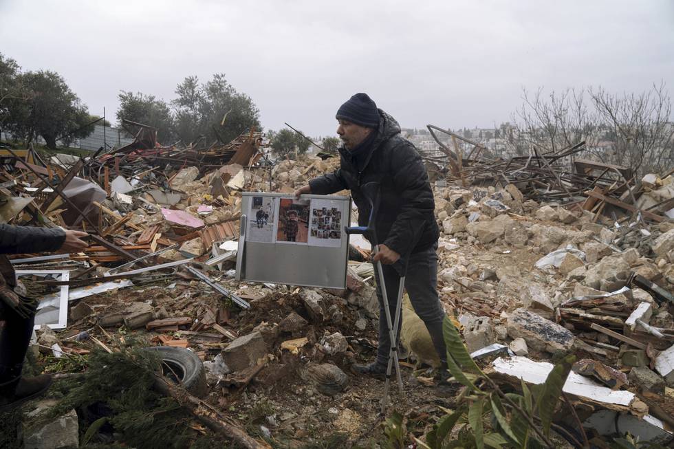 En palestinsk mann har funnet et album med familiebilder i ruinene av huset etter at Israel rev familiens bolig i Sheikh Jarrah i det okkuperte Øst-Jerusalem. Foto: Mahmoud Illean / AP / NTB