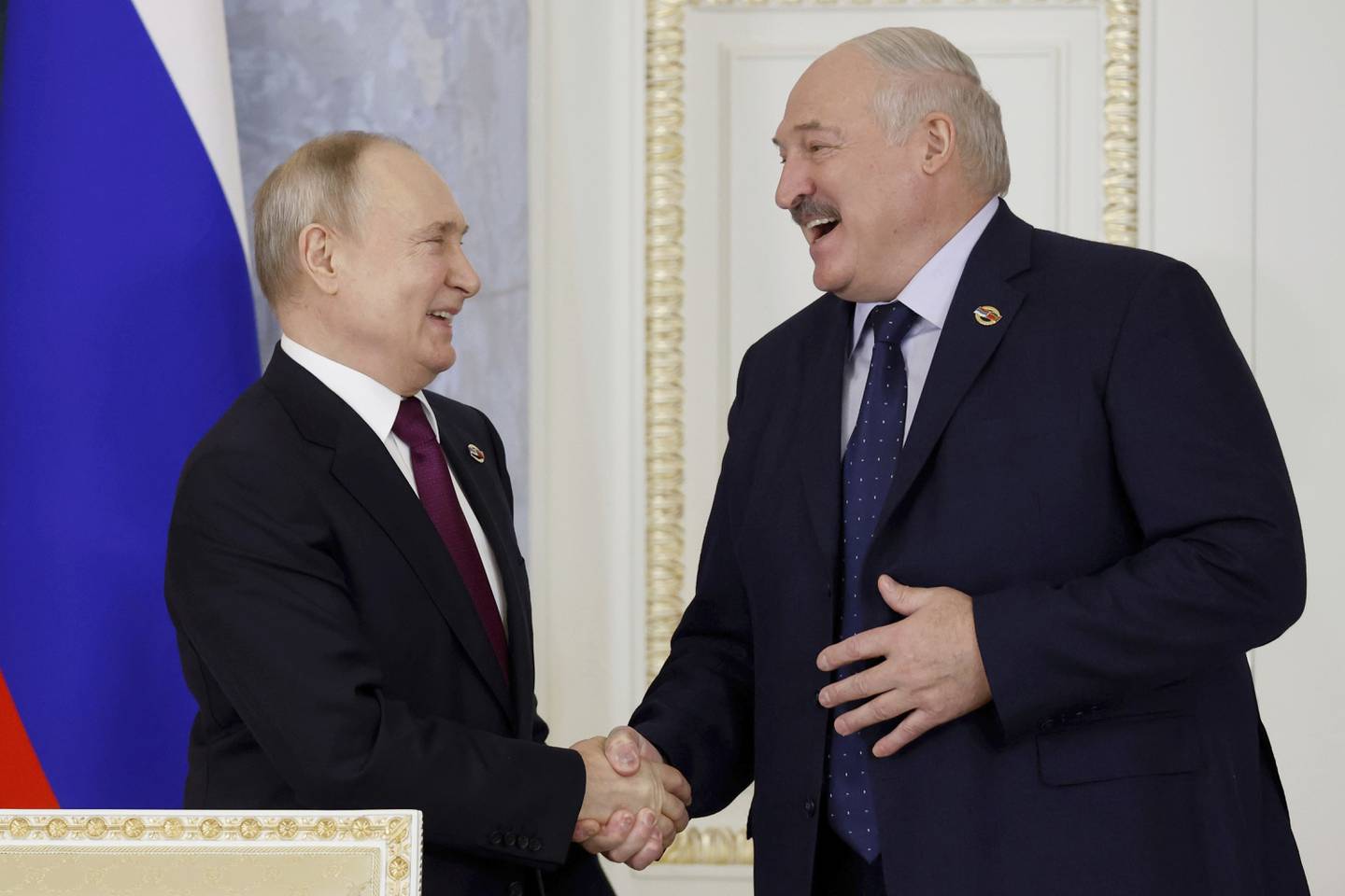 Russian President Vladimir Putin, left, and Belarus President Alexander Lukashenko smile as they shake hands during a meeting of the Union State Supreme Council in St. Petersburg, Russia, Monday, Jan. 29, 2024. (Dmitry Astakhov, Sputnik, Government Pool Photo via AP)