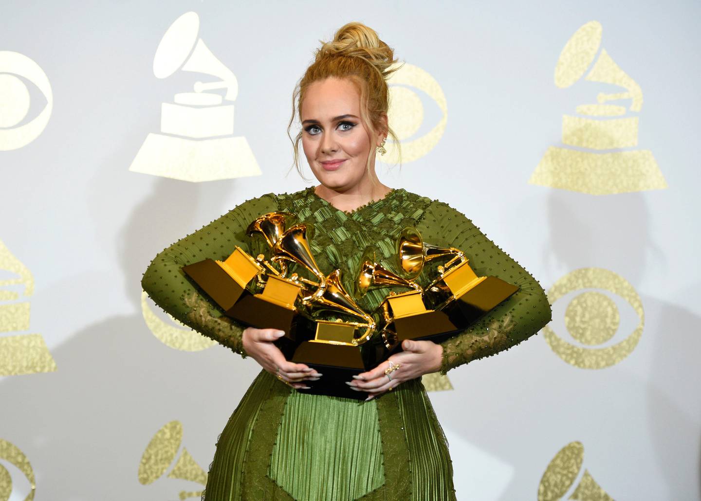 Adele poses in the press room with the awards for album of the year for "25", song of the year for "Hello", record of the year for "Hello", best pop solo performance for "Hello", and best pop vocal album for "25" at the 59th annual Grammy Awards at the Staples Center on Sunday, Feb. 12, 2017, in Los Angeles. (Photo by Chris Pizzello/Invision/AP)