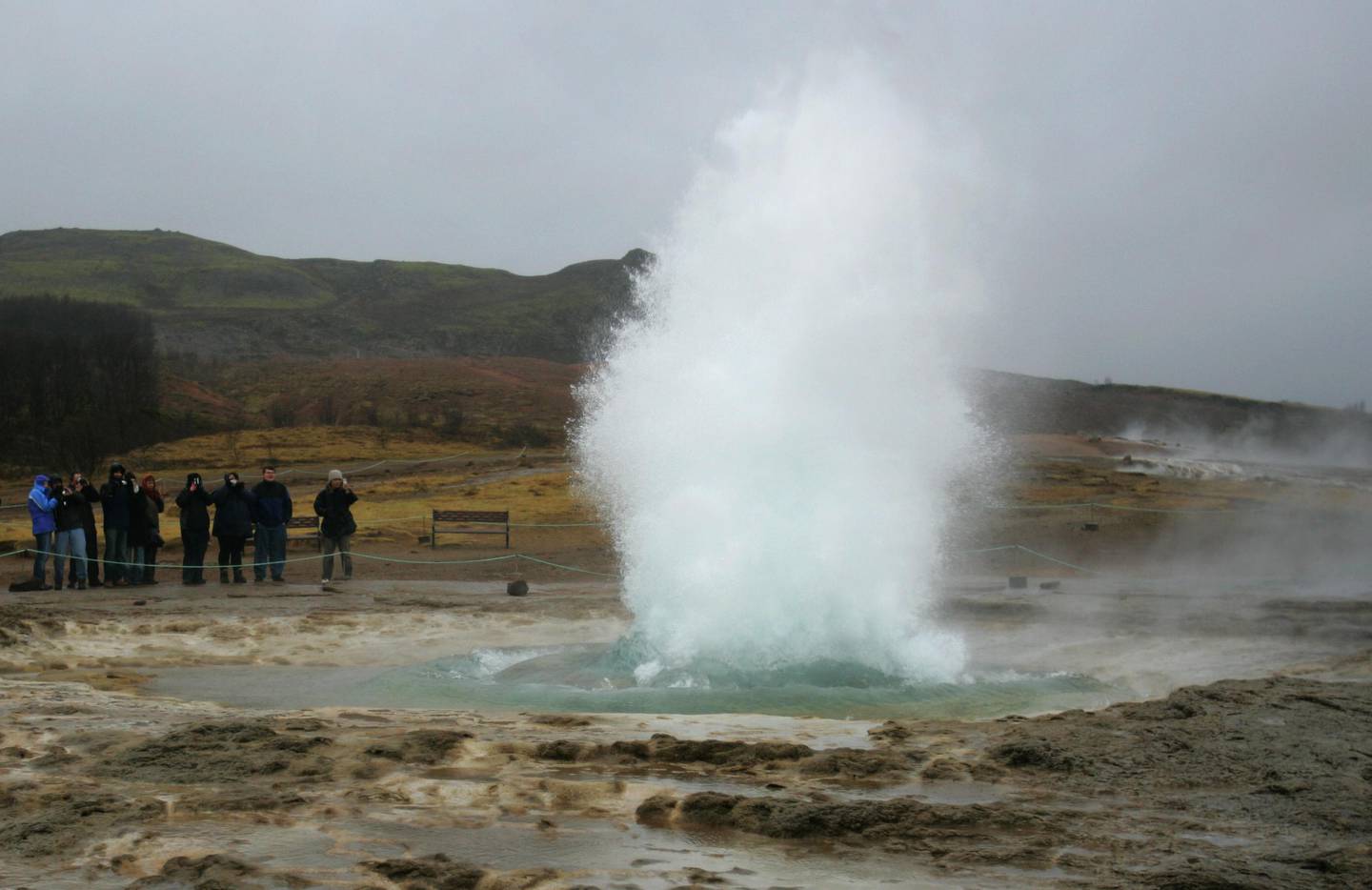 ** FOR IMMEDIATE RELEASE ** Tourists watch the Strokkur hot spring erupt, at the site of Geysir, Iceland, Feb. 22, 2006. Part of the 'Golden Circle' tour, the Geysir area, part of the natural phenomena in the country, it is one of the most popular tourist attractions.  (AP Photo/Kirsty Wigglesworth) 