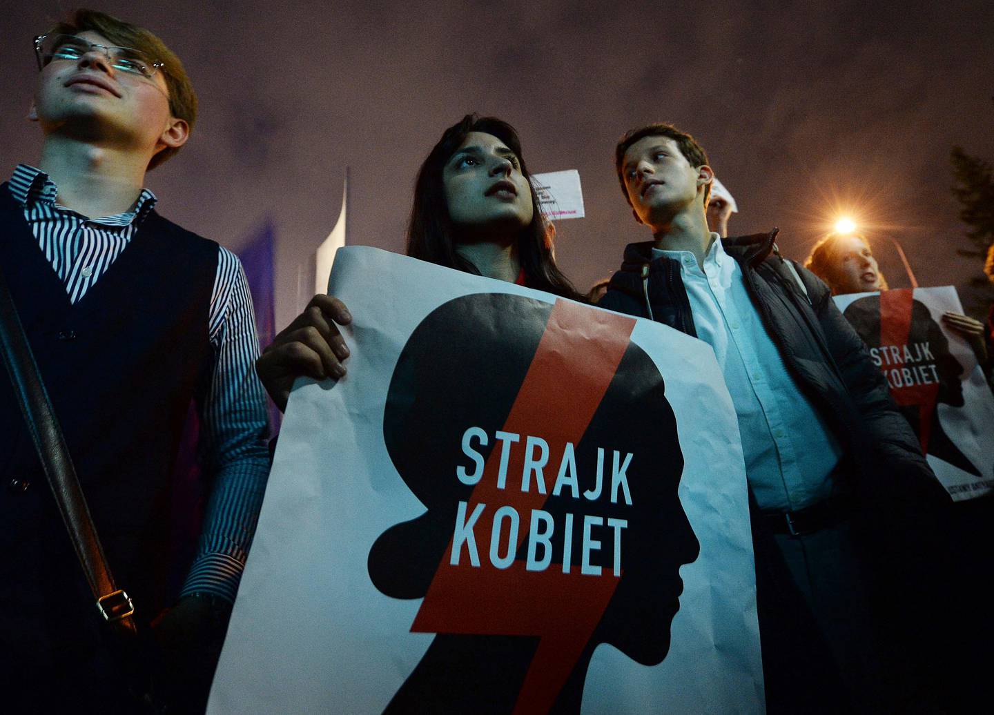 People attend a protest against a bill that would criminalize "the promotion of underage sex" in front of the Parliament in Warsaw, Poland, Wednesday, Oct. 16, 2019. The poster reads: "Women Strike". (AP Photo/Czarek Sokolowski)