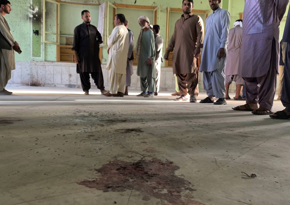 En gruppe menn står inne i moskeen i Kandahar i Afghanistan. Over 30 mennesker ble drept og flere enn 70 såret i et selvmordsangrep fredag. Foto: Sidiqullah Khan / AP / NTB