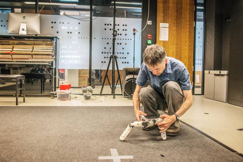 Ved institutt for informatikk på Blindern har de laget roboter som selv finner ut hvordan de burde bevege seg. Professor Jim Tørresen viser fram en av robotene som en stipendiat står bak.