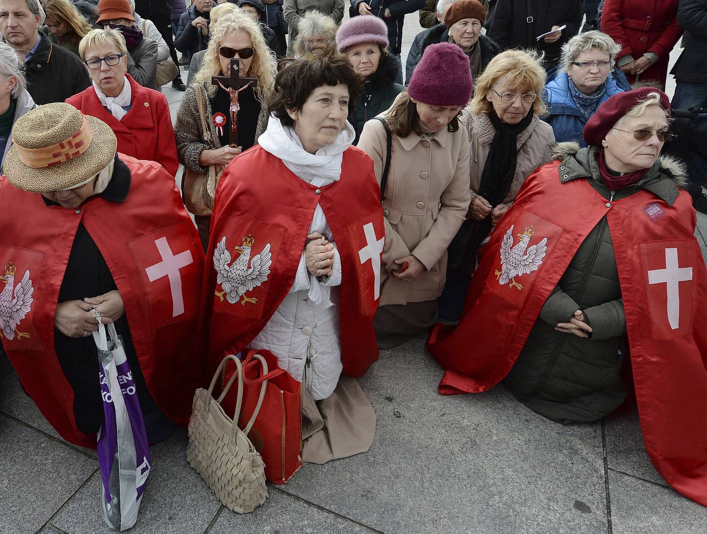 In this Oct. 5, 2019, photo, Polish Catholics pray at an anti-gay event in Warsaw, Poland. About 200 people marched holding rosaries and crucifixes and praying to apologize for what they say is the desecration of pride parades. (AP Photo/Czarek Sokolowski)