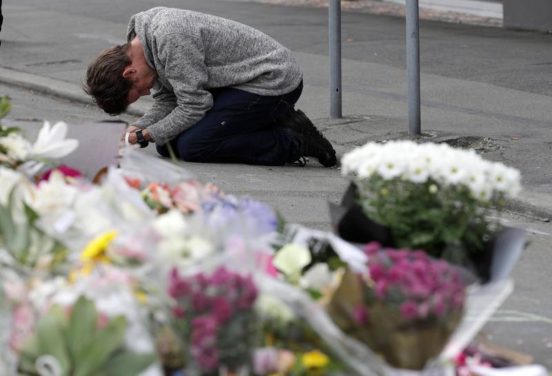 A mourner prays near the Linwood mosque in Christchurch, New Zealand, Tuesday, March 19, 2019. Christchurch was beginning to return to a semblance of normalcy Tuesday. Streets near the hospital that had been closed for four days reopened to traffic as relatives and friends of Friday's shooting victims continued to stream in from around the world. (AP Photo/Mark Baker)
