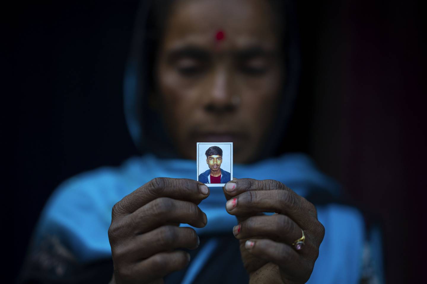 Radha Rani Mondal, 50, shows the photograph of her son, who was arrested by police in Morigaon district of Indian northeastern state of Assam, Friday, Feb. 10, 2023. Mondal's 20-year-old son was arrested on 4 February and her 17-year-old daughter-in-law is pregnant. She spent her last 500 rupees ($6 ) to hire a lawyer, whom she owes 20,000 rupees ($ 250 ) more. More than 3,000 men, including Hindu and Muslim priests, who were arrested nearly two weeks ago in the northeastern state of Assam under a wide crackdown on illegal child marriages involving girls under the age of 18. (AP Photo/Anupam Nath)