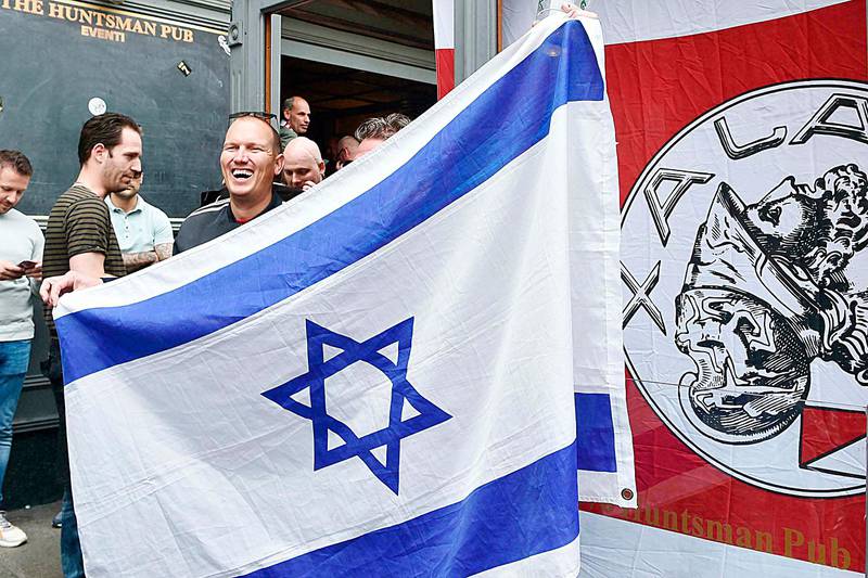 An Ajax supporter holds an Israeli flag prior to the Champions League, quarterfinal, second leg soccer match between Juventus and Ajax, in downtown Turin, Italy, Tuesday, April 16, 2019. (Alessandro Di Marco/ANSA via AP)