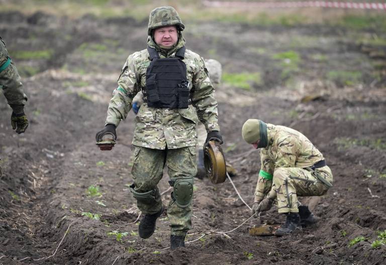 Interior ministry sappers defuse mines on a mine field after recent battles in Irpin close to Kyiv, Ukraine, Tuesday, April 19, 2022. (AP Photo/Efrem Lukatsky)