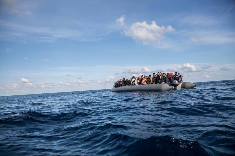 In this Friday, Dec. 21, 2018, photo, migrants sit in a rubber dinghy after Proactiva Open Arms, a Spanish NGO, spotted and rescued them in the Central Mediterranean Sea at 45 miles (72 kilometers) from Al Khums, Lybia. The Spanish NGO Open Arms have rescued about 300 migrants from 3 boats crossing the Mediterranean from North Africa to Europe on Friday. (AP Photo/Olmo Calvo)