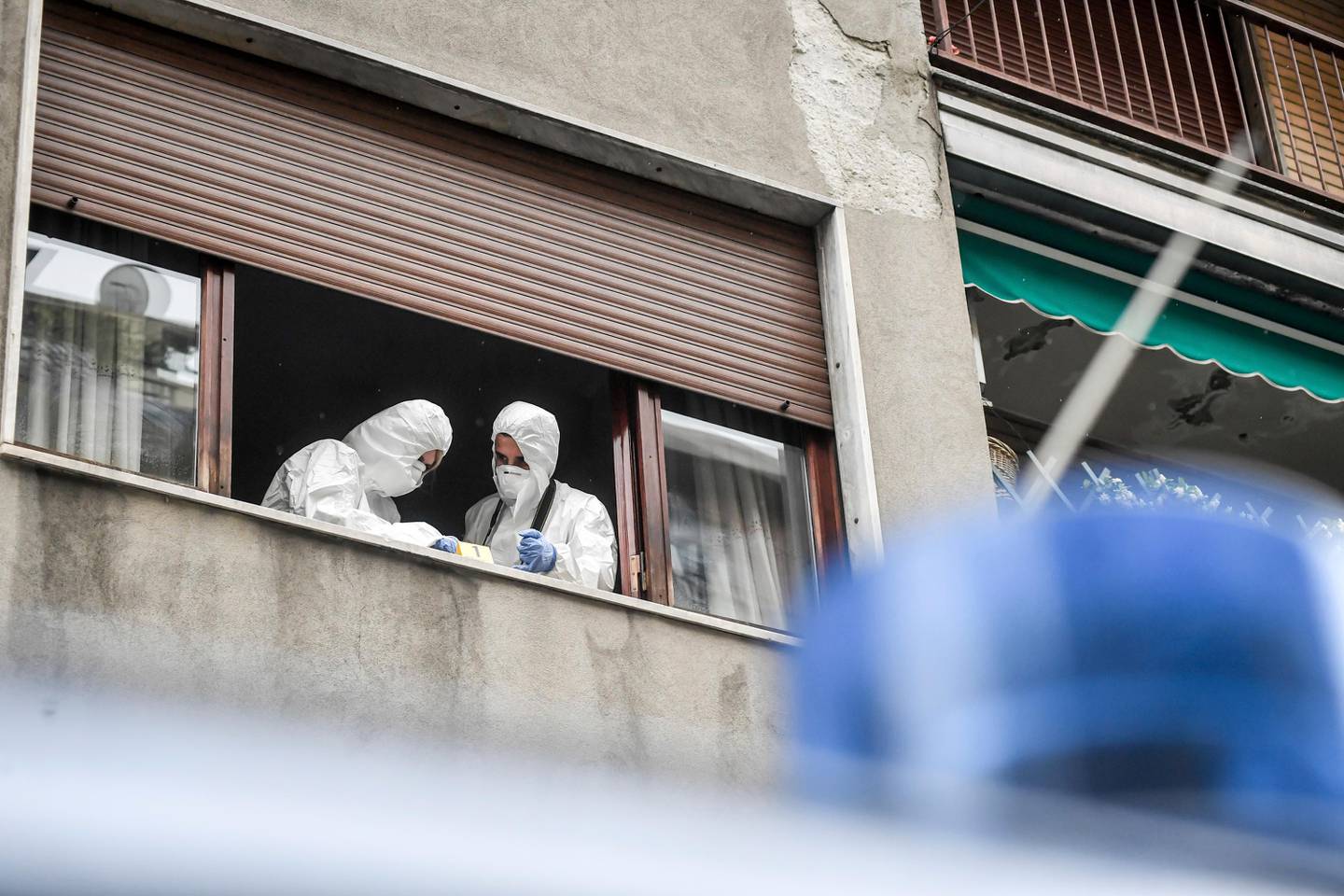 Forensic police officers at work after being called to the Silvia Romano family apartment in Milan, Wednesday, May 13, 2020 after a glass bottle was thrown against the building. A right-wing lawmaker was reprimanded Wednesday for having called a young Italian woman held hostage in Somalia by Muslim extremists a neo-terrorist after she returned home having apparently converted to Islam. Silvia Romano, 24, stepped off an Italian government jet on Sunday wearing the green hijab typical of Somali Muslim women. (Claudio Furlan/LaPresse via AP)