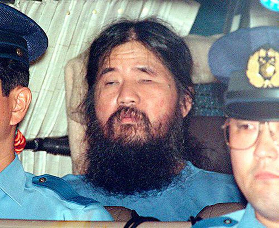 FILE - In this Sept. 25, 1995, file photo, Japanese doomsday cult leader Shoko Asahara, center, sits in a police van following an interrogation in Tokyo. Japanese media reports say on Friday, July 6, 2018, Asahara, who has been on death row for masterminding the 1995 deadly Tokyo subway gassing and other crimes, has been executed. He was 63. (Kyodo News via AP, File)