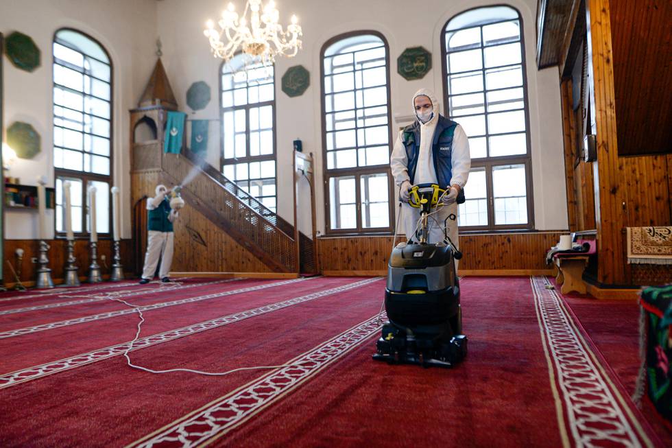 Workers disinfect the Cobanija mosque in Sarajevo, Bosnia, Tuesday, April 21, 2020. Disinfection began in mosques in the Bosnian capital Sarajevo and throughout the country, in order to limit the spread of the COVID-19 infections, ahead of holy month of Ramadan, although prayers will only be attended by Islamic clerics as the rest of the community observes government restrictions on public gatherings and religious ceremonies.(AP Photo/Kemal Softic)