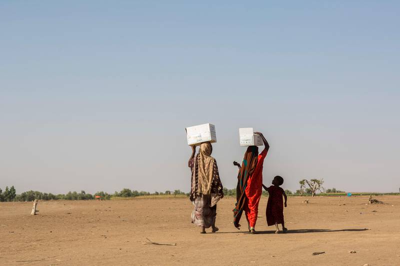 Pastoralist women displaced by drought carry food rations from a distribution point to the Farburo site for internally-displaced people in Gode, in the Somali region of Ethiopia Saturday, Jan. 27, 2018. Despite economic growth in the past decade, rural areas continue to suffer as the nation faces drought, leaving millions requiring emergency food assistance. (AP Photo/Mulugeta Ayene)