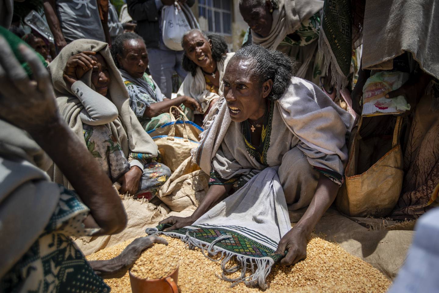 En etiopisk kvinne krangler med andre over bønner utdelt av en nødhjelpsorganisasjon i Tigray-regionen. IRC mener den humanitære krisen i Etiopia vil forverres i 2022. Foto: Ben Curtis / AP / NTB