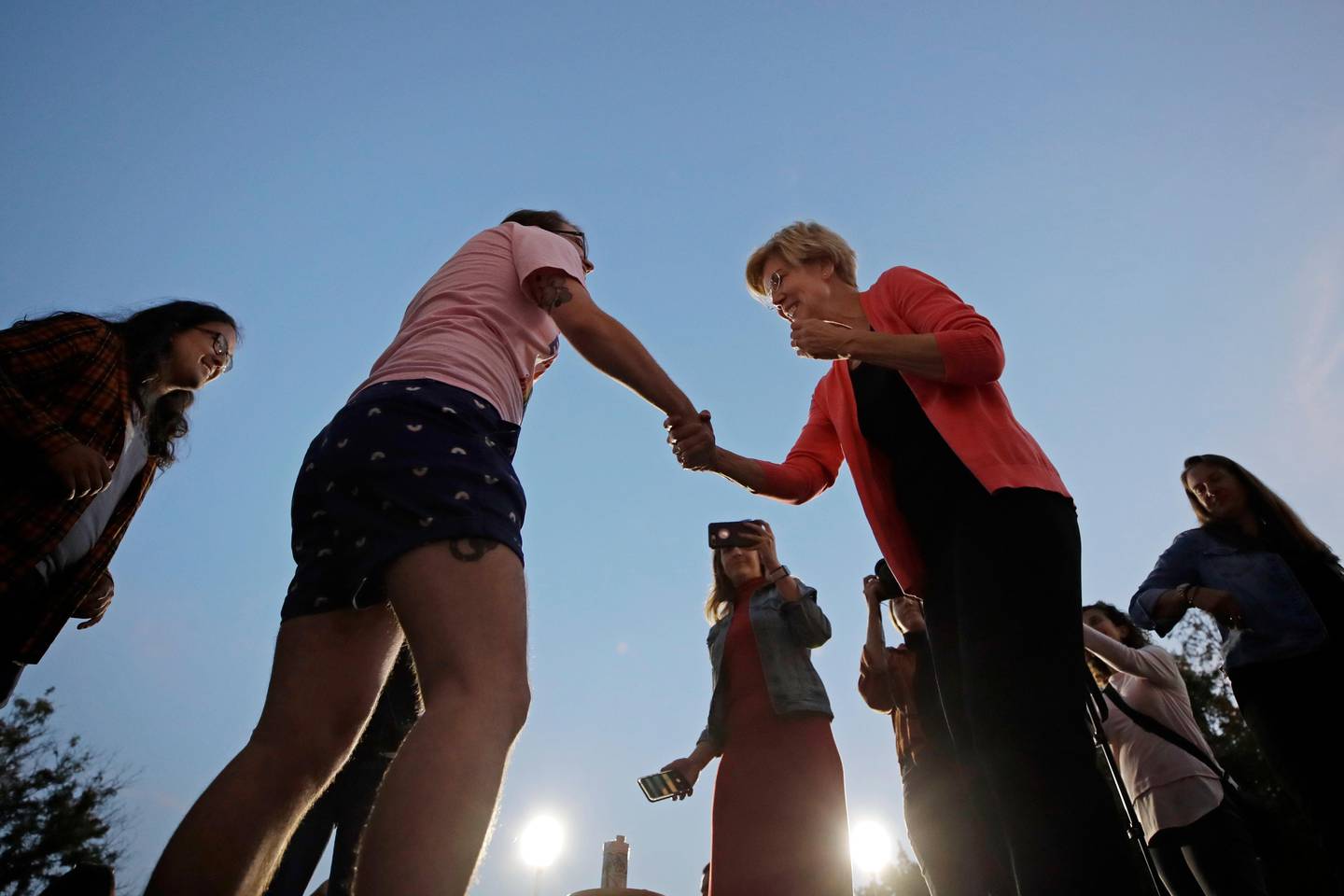 Democratic presidential candidate Sen. Elizabeth Warren, D-Mass., right, shakes during a "selfie line" at a campaign event, Wednesday, Sept. 25, 2019, in Keene, N.H. (AP Photo/Elise Amendola)