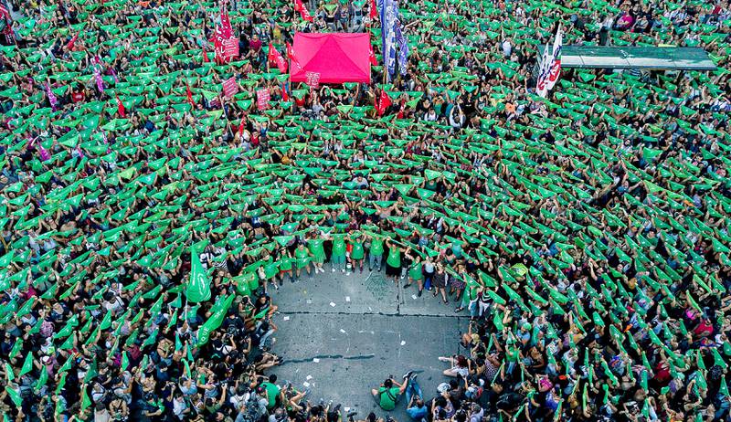 In this Tuesday, Feb. 19, 2019 photo, pro-choice activists in favor of decriminalizing abortion raise green handkerchiefs as they rally outside Congress in Buenos Aires, Argentina. Demonstrators are demanding the decriminalization of the voluntary interruption of pregnancy and that the issue be included in this year's parliamentary agenda, after lawmakers voted against the decriminalization of abortion last year. (AP Photo/Tomas F. Cuesta)