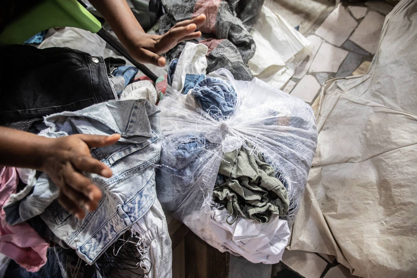 KASTES: En stor del av klærne i hver ball kaster kleselgeren Florence Agbeawotsia. Klærne som hun har bundet sammen her, blir tatt av søppelbiler i slutten av dagen.