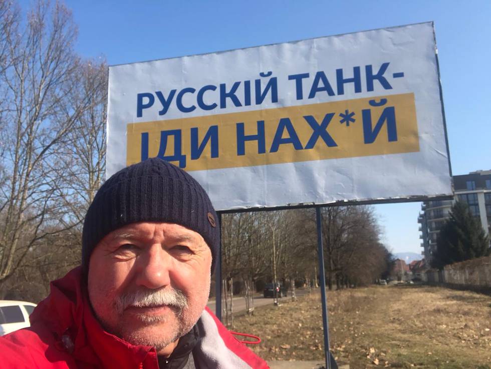 Forfatter Andrej Kurkov er klar til kamp. Her har han tatt en selfie foran et skilt som sier «Russiske tanks: Dra til h***»
