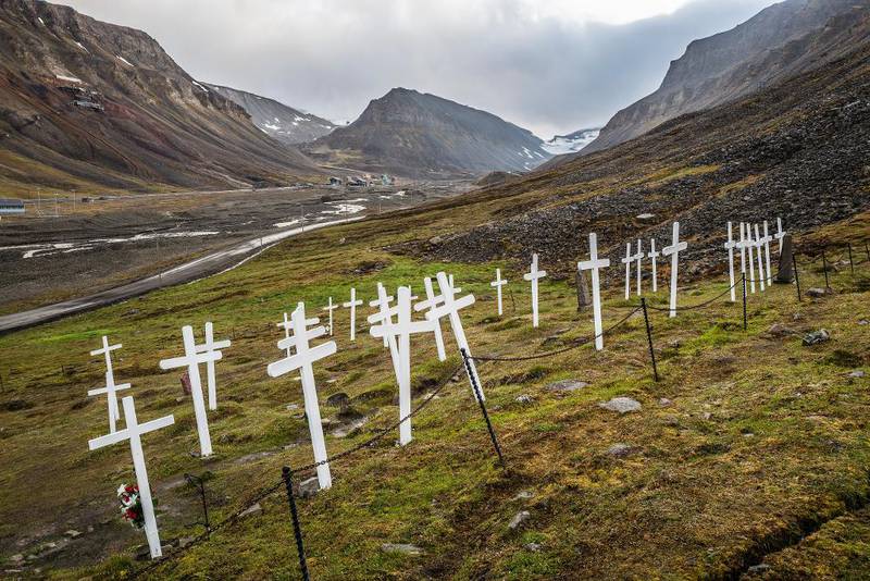 Store Norske har i snart 100 år vært grunnlaget for en norsk bosetting i Longyearbyen. På kirkegården ligger blant annet de 26 ofrene fra kullstøveksplosjonen i Gruve 1 i 1920. Øverst til venstre i bildet ligger Gruve 2B, som var i drift fra 1937 til 1968.