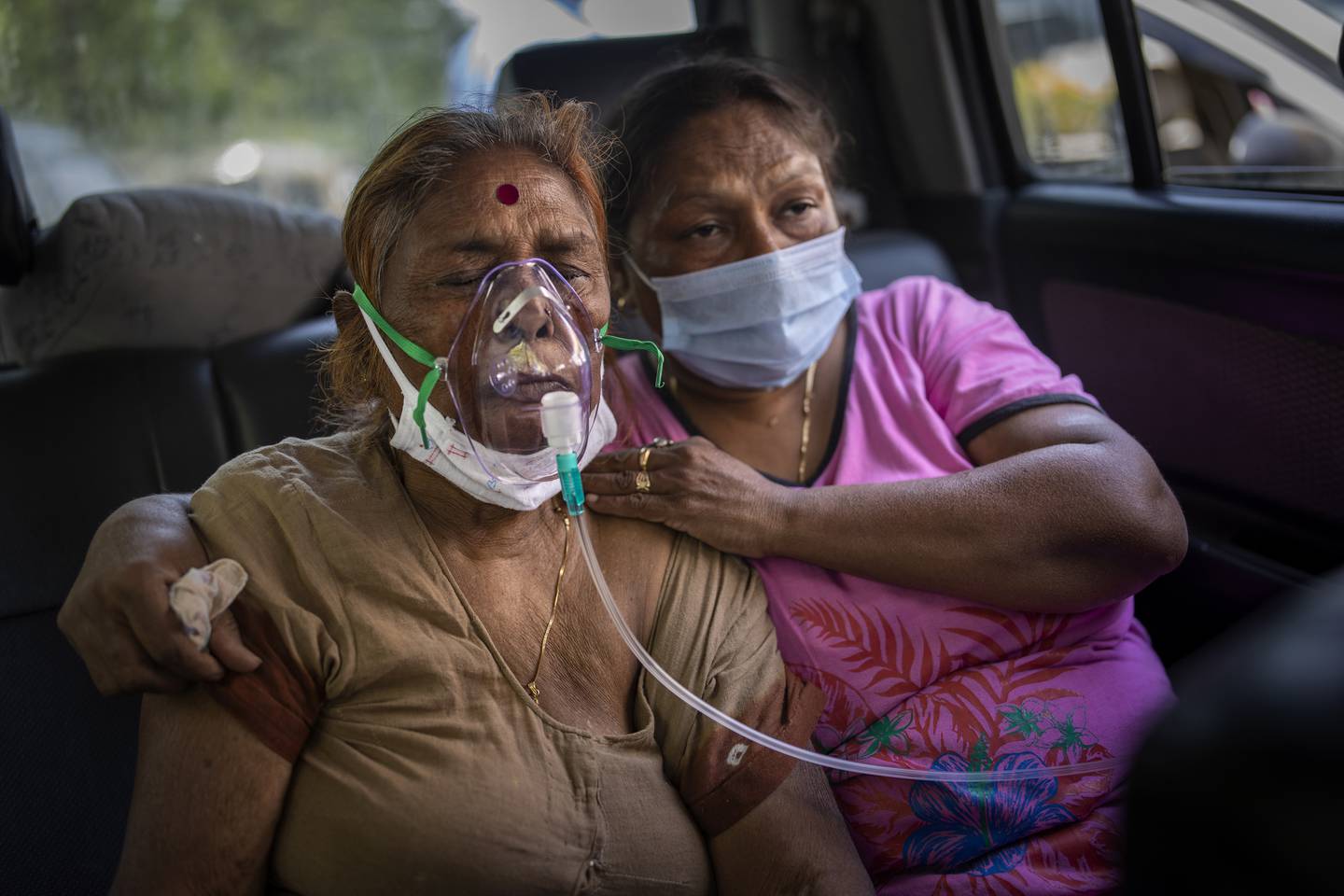 Kritisk syke koronapasienter dør på gata på grunn av mangelen på ledige sykehussenger og oksygen. Denne kvinnen får oksygen i en bil i New Delhi. Foto: AP / NTB