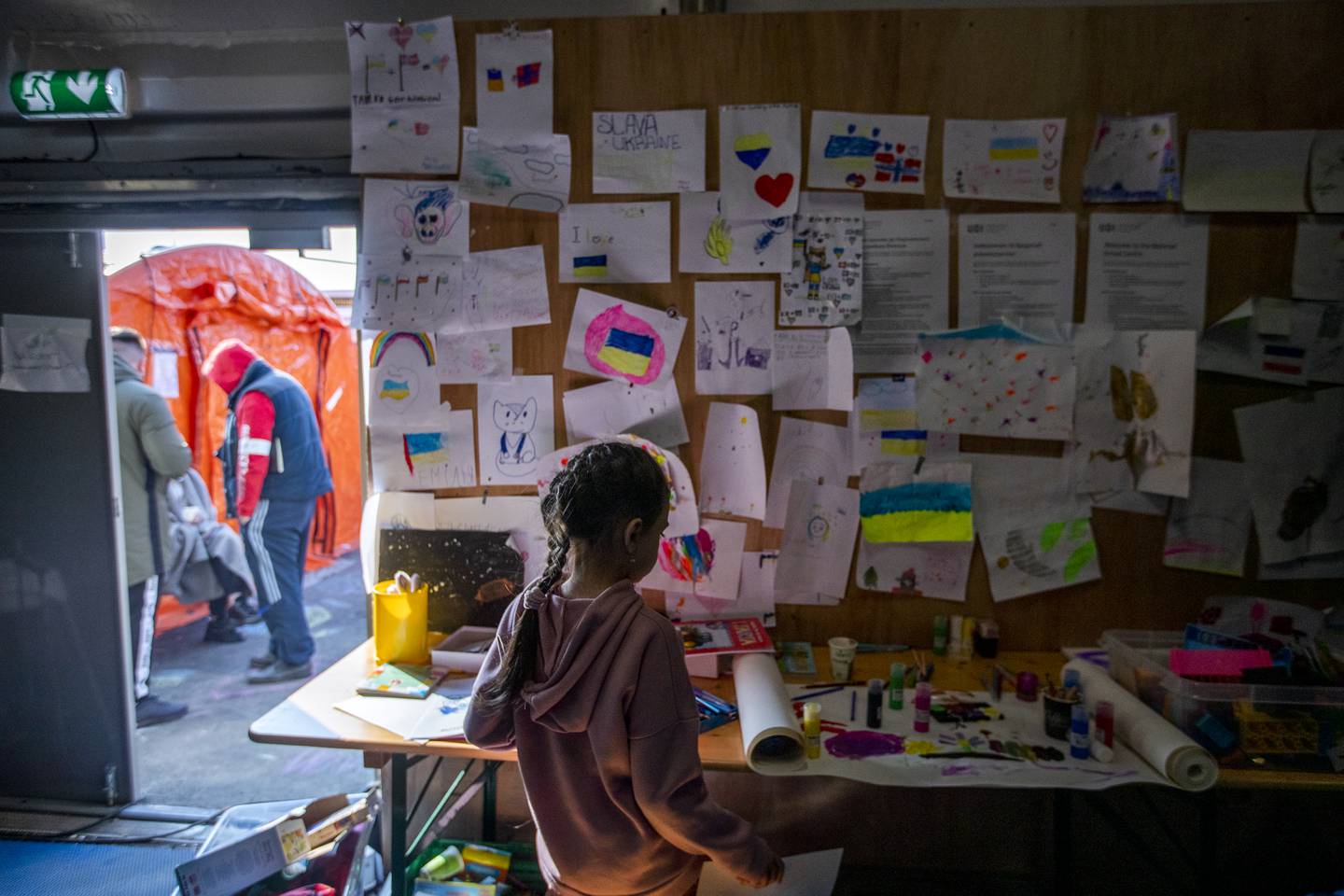 Bildet viser en jente som sitter foran tegninger. Ukrainske flyktninger kom til Nasjonalt mottakssenter i Råde i 2022. Norges kommuner forbereder seg på å ta imot flere flyktninger i 2023.
