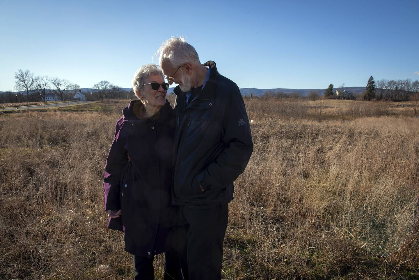 Jim and Letty Carpenter walk in a field near their home in Frederick, Md., Tuesday, Jan. 19, 2021. Jim, who cheers Biden as the rightful winner, is a member the Braver Angels program and meets regularly with neighbor Natalie Abbas, who believes the election was stolen, to ponder the greatest challenge facing Biden and American society: how can they find common ground if they no longer exist in the same reality? (AP Photo/Cliff Owen)