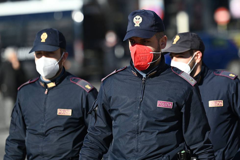 Policemen from the Polizia di Stato police force, one wearing a coloured face mask, patrol in downtown Rome on January 14, 2022. - A union of Italian police officers has denounced the allocation of pink FFP2 masks to the police in some provinces of the country, a colour which it says is likely to "damage the image of the institution". In a letter to the head of the national police force published on its website, the secretary general of the Autonomous Police Union (SAP) protested against these "protective devices of an eccentric colour in relation to the uniform, and which risk damaging the image of the institution". (Photo by Vincenzo PINTO / AFP)