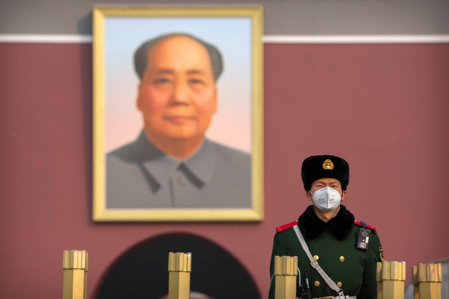 A paramilitary policeman wears a face mask as he stands guard near the large portrait of Chinese leader Mao Zedong at Tiananmen Gate adjacent to Tiananmen Square in Beijing, Monday, Jan. 27, 2020. China on Monday expanded sweeping efforts to contain a viral disease by postponing the end of this week's Lunar New Year holiday to keep the public at home and avoid spreading infection as the death toll rose to 80. (AP Photo/Mark Schiefelbein)