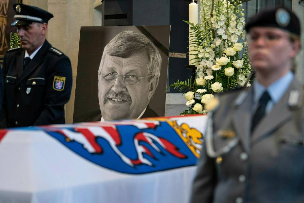 FILE-In this June 13, 2019 file photo a picture of Walter Luebcke stands behind his coffin during the funeral service in Kassel, Germany. Germany's top security official says the far-right extremist suspected in the killing of a politician from Chancellor Angela Merkel's party has told authorities that he acted alone. Walter Luebcke, who led the Kassel regional administration in central Germany, was fatally shot in the head at his home on June 2. (Swen Pfoertner/dpa via AP)