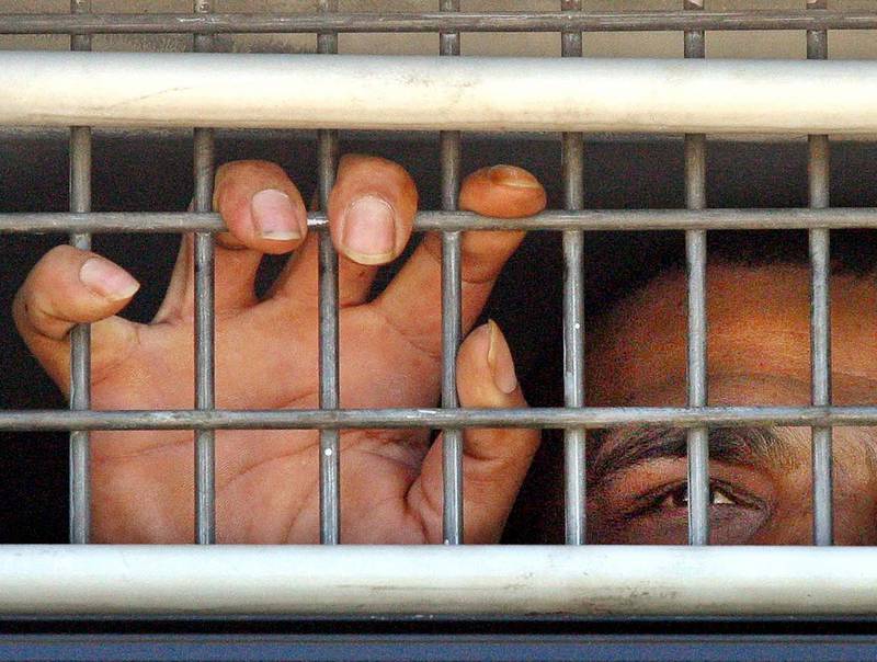 A Palestinian prisoner is seen behind bars as he is brought into the Hadariam prison, north of Tel Aviv Sunday Aug. 15, 2004. About 1,600 Palestinian prisoners began a hunger strike Sunday to protest conditions in Israeli jails, but Israel's Public Security Minister has said they can 
