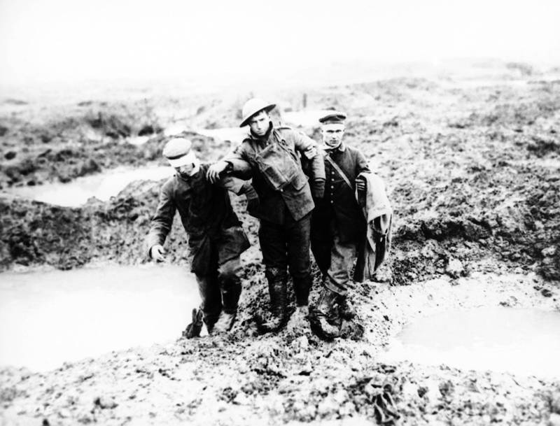 SIXTY EIGHT OF ONE HUNDRED PHOTOS WORLD WAR ONE CENTENARY  TIMELINE -  In this 1917 file photo, wounded Canadian and German World War One soldiers help one another through the mud during the Battle of Passchendaele in Passchendaele, Belgium. (AP Photo/File)