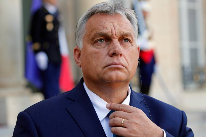 Hungarian Prime Minister Viktor Orban adjusts his tie during a joint statement with French President Emmanuel Macron prior to their meeting at the Elysee Palace in Paris, Friday, Oct. 11, 2019. (AP Photo/Francois Mori)