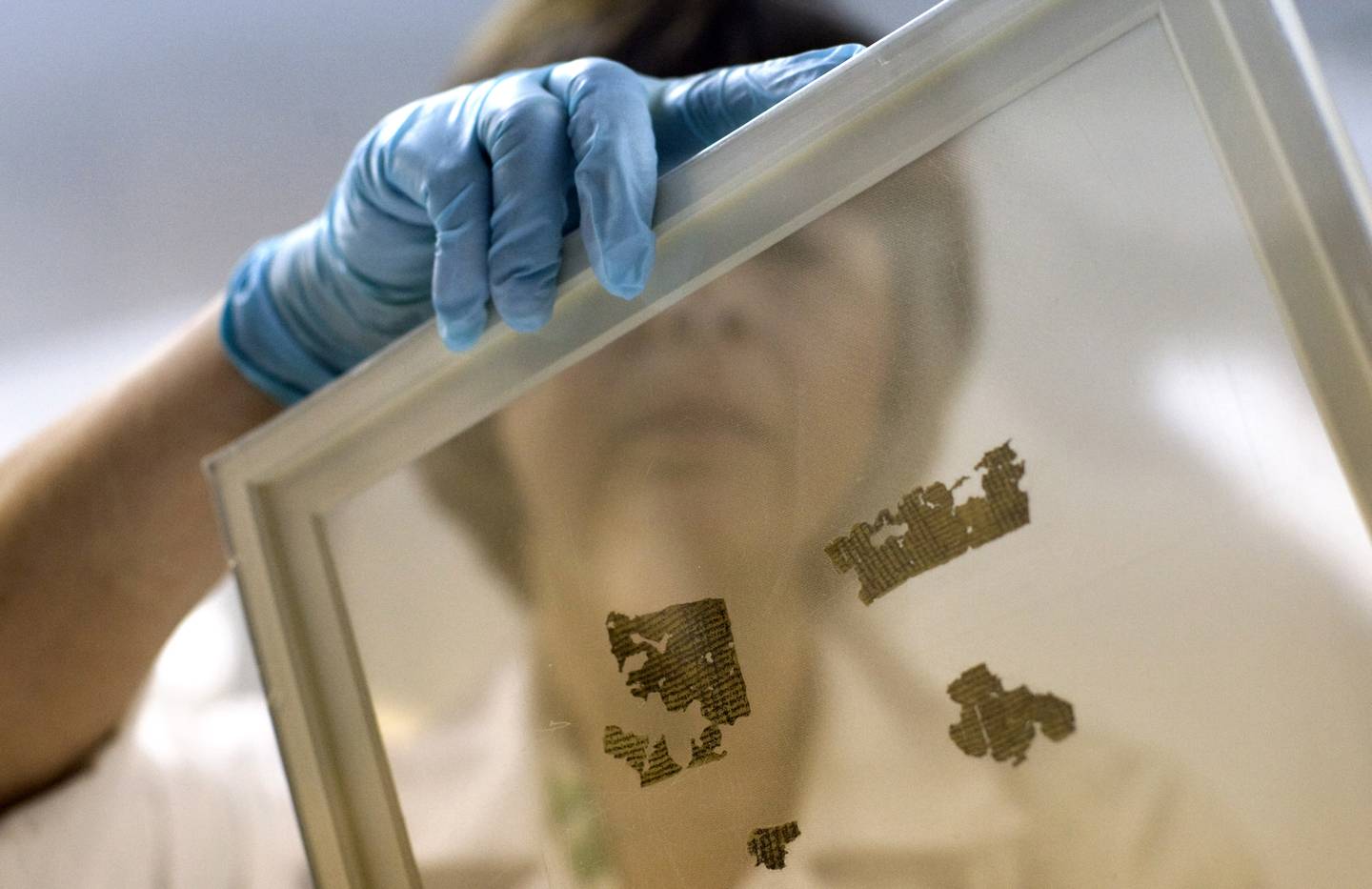 OPPBEVARING: Fragmenter av Dødehavsrullene oppbevares ofte på glassplater som dette. Her viser forsker Lena Libman fram noen små fragmenter fra et annet manuskript som også skal være nedtegning av bøker fra Det gamle testamentet.
