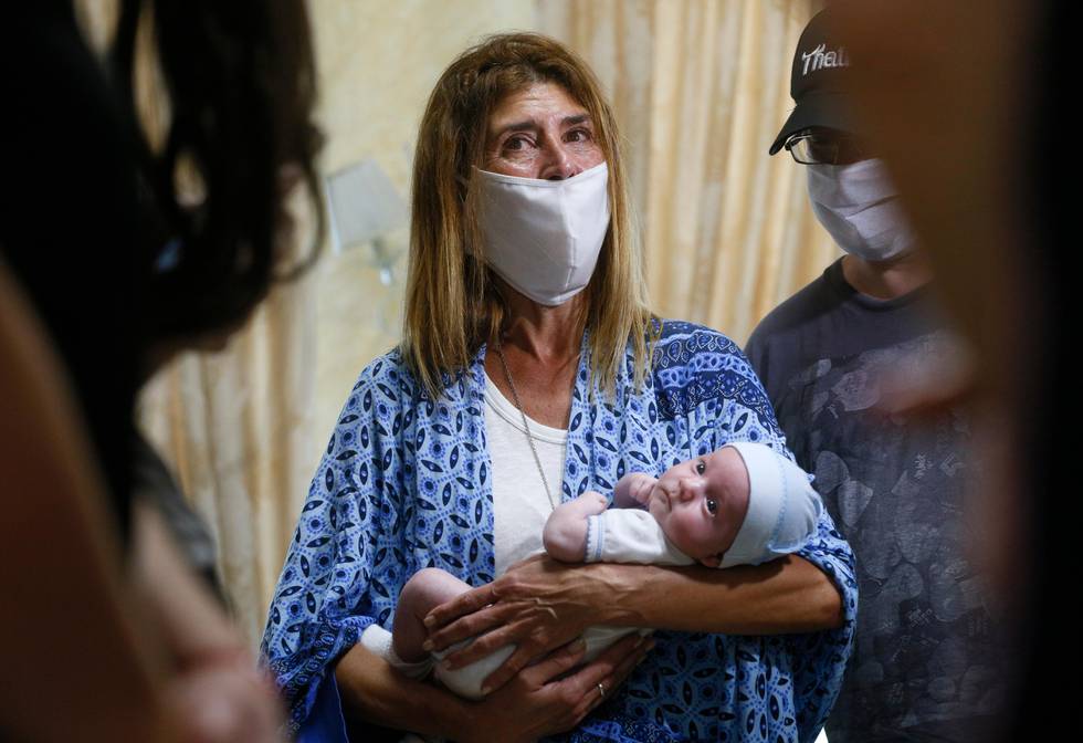 Andreo Diez, from Buenos Aires, Argentina, holds Ignacio, her baby born via a Ukrainian surrogate mother for the first time, after spending two weeks in quarantine, due to the coronavirus outbreak,  in a hotel where the Biotexcom clinic, the country's largest surrogate operation, puts up clients, in Kyiv, Ukraine, Wednesday, June 10, 2020. Authorities in Ukraine have allowed foreign parents to enter the country and collect their babies, born to surrogate mothers and stranded in Ukraine after its borders shut down under coronavirus restrictions. Thirty-one couples have arrived to Ukraine and have reunited with the infants, while 88 more families were on the way, Ukraines human rights ombudswoman Lyudmila Denisova said Wednesday. (AP Photo/Efrem Lukatsky)