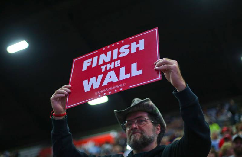 A supporter holds up a sign which reads, "FINISH THE WALL" as he waits to hear President Donald Trump speak at a campaign rally at WesBanco Arena, Saturday, Sept. 29, 2018, in Wheeling, W.Va. (AP Photo/Pablo Martinez Monsivais)