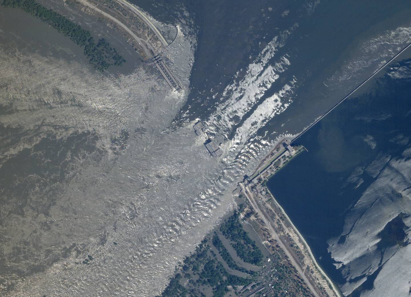 Satellittbilde viser den revnede Kakhovka-demningen sør i Ukraina. Foto: Planet Labs PBC via AP / NTB