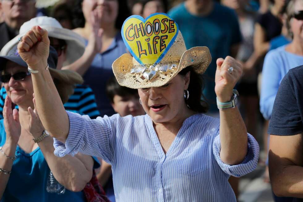Kathy Calver cheers for a speaker as she and other anti-abortion activists rally on the steps of the Texas Capitol to condemn the use in medical research of tissue samples obtained from aborted fetuses, Tuesday, July 28, 2015, in Austin, Texas. (AP Photo/Eric Gay)