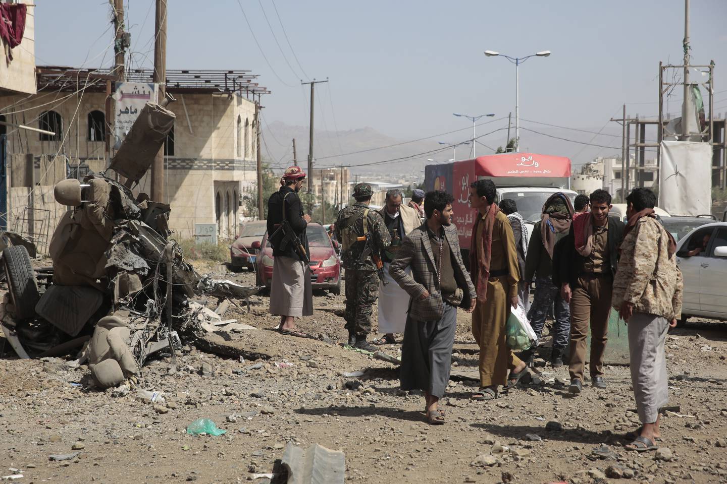 Det som er igjen etter et luftangrep i Sana, Jemen, blir inspisert av lokalbefolkningen. Krigen i Jemen har ført til et stort nødhjelpsbehov, og IRC mener situasjonen ikke ser ut til å bedre seg. Foto: Hani Mohammed / AP / NTB