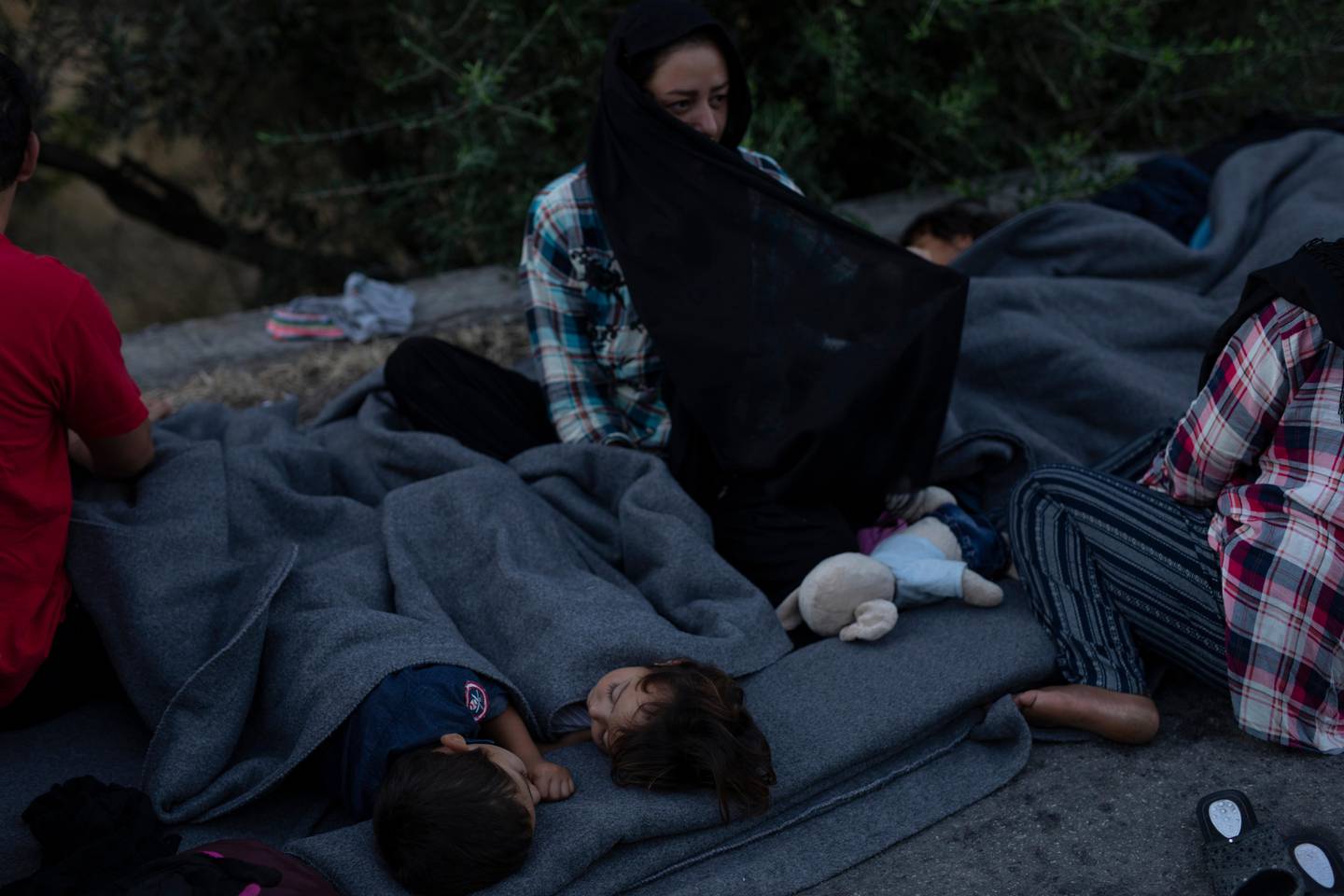Migrants sleep on the road near the Moria refugee camp on the northeastern island of Lesbos, Greece, Thursday, Sept. 10, 2020. A second fire in Greece's notoriously overcrowded Moria refugee camp destroyed nearly everything that had been spared in the original blaze, Greece's migration ministry said Thursday, leaving thousands more people in need of emergency housing. (AP Photo/Petros Giannakouris)