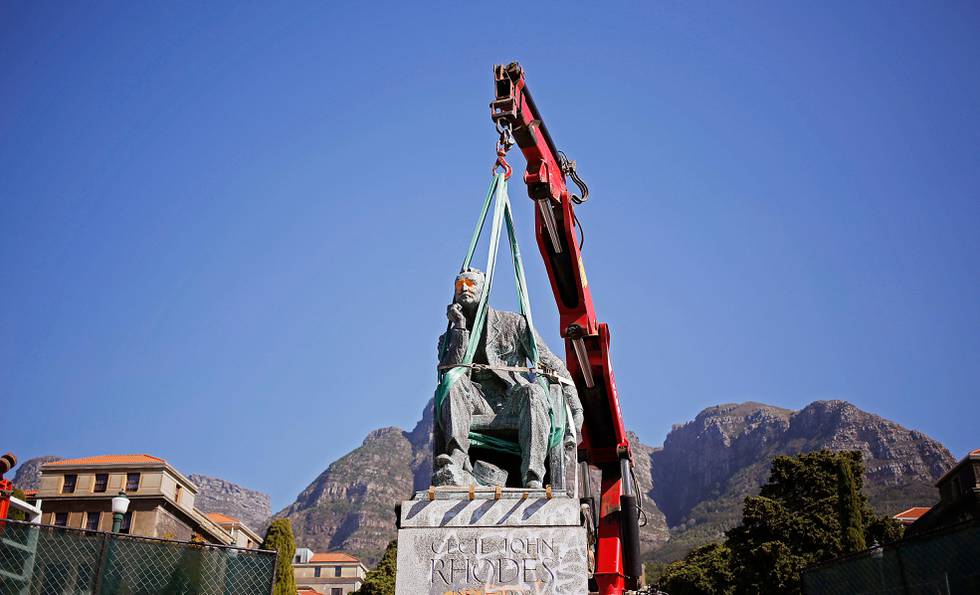 FILE - In this Thursday April 9, 2015 file photo, a crane prepares to remove the statue of British colonialist Cecil John Rhodes at the Cape Town University, South Africa. The University removes the statue of British colonialist Cecil John Rhodes after weeks of protest by students, who said the statue had become a symbol of the slow racial transformation on campus. (AP Photo/Schalk van Zuydam, File)