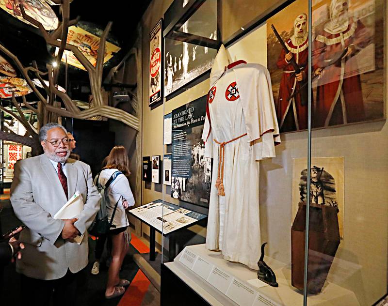 Lonnie Bunch, founding director of the Smithsonian's National Museum of African American History and Culture, left, comments about a displayed KKK robe, during a tour of the state's two museums, the Museum of Mississippi History and the Mississippi Civil Rights Museum, Thursday, April 19, 2018. Bunch also delivered a lecture at a neighboring church as part of the Medgar Wiley Evers Lecture Series, partially sponsored by the Mississippi Department of Archives and History. (AP Photo/Rogelio V. Solis)